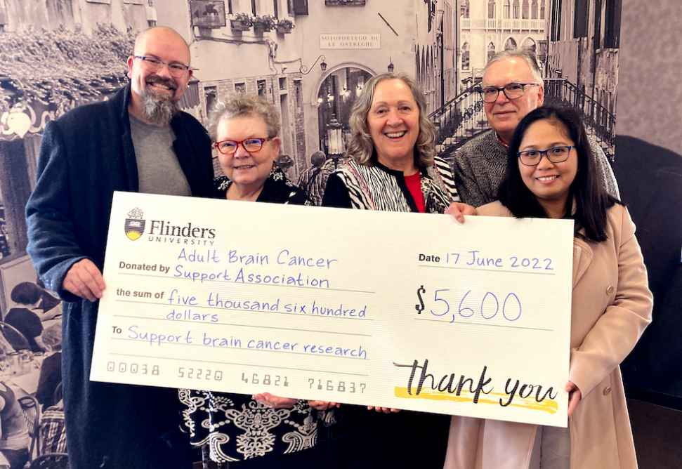 A group of people holding a novelty cheque