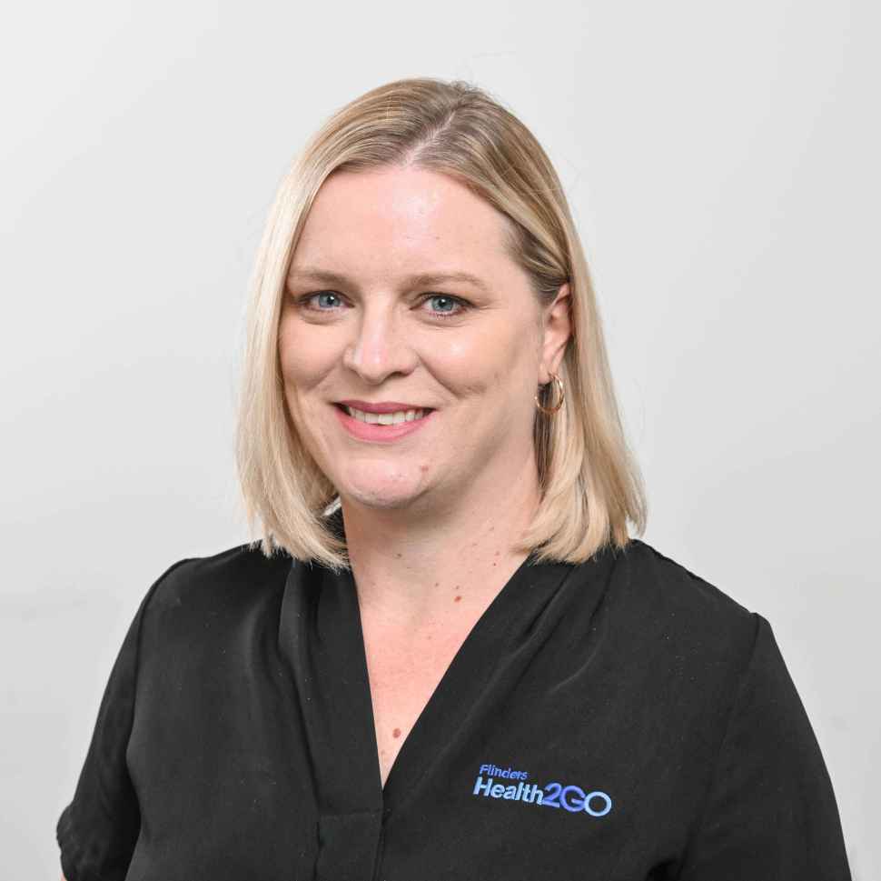 A woman wearing a black polo behind a white backdrop